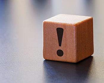 Wooden block with exclamation mark on it