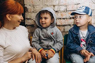 Ukrainian refugee children talking to a woman
