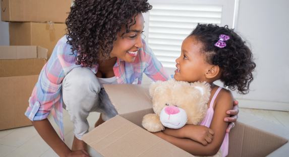 mom and daughter in front of cardboard boxes