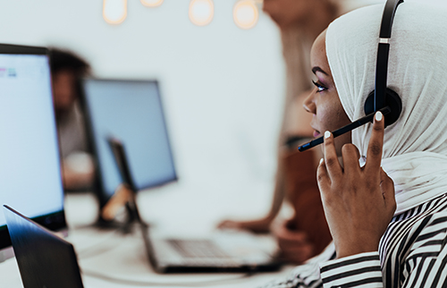 Muslim woman working with hijab and headset in a modern office