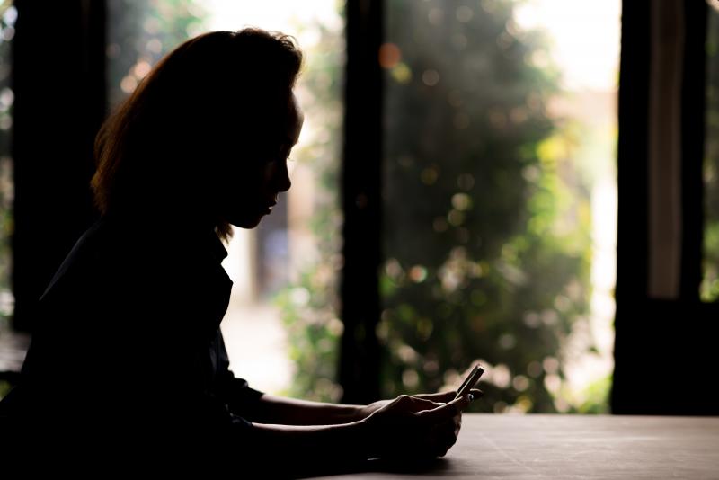 silhouette of woman holding a phone